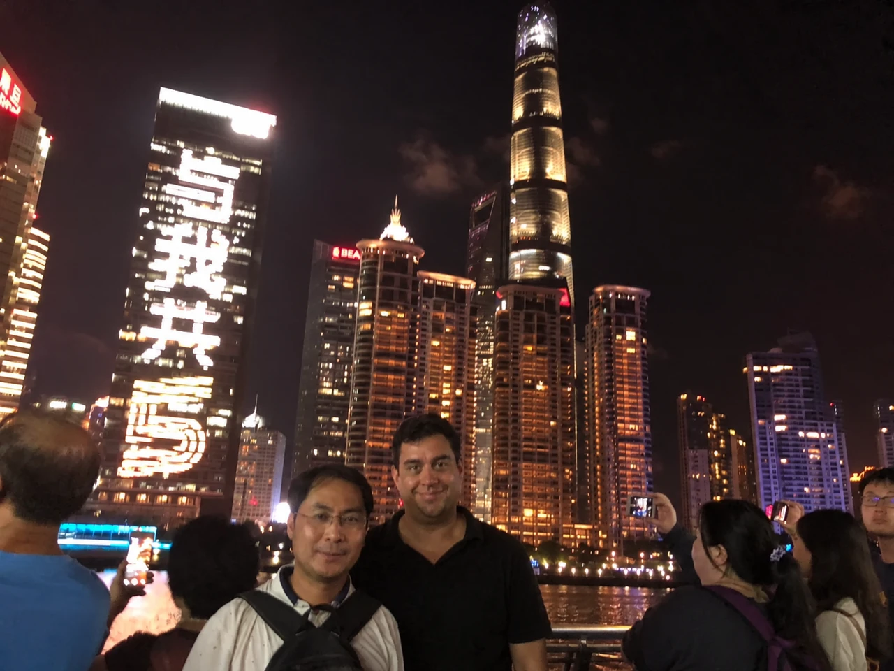 Gemeinsamer Abend beim Lieferantenbesuch in China vor der beleuchteten Stadtkulisse