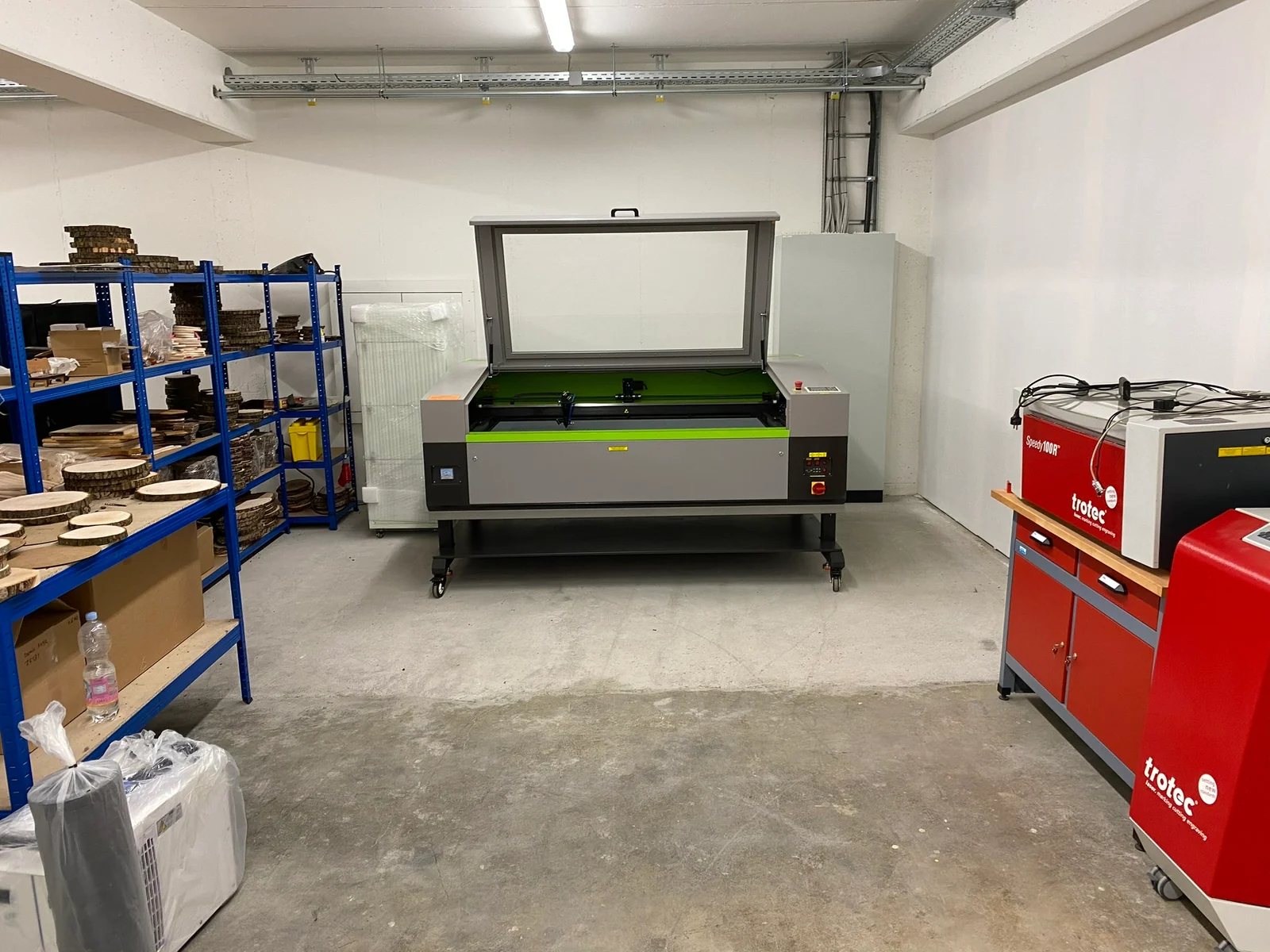 Ein größerer grüner Laser steht neben dem roten Trotec in der eigenen Werkstatt